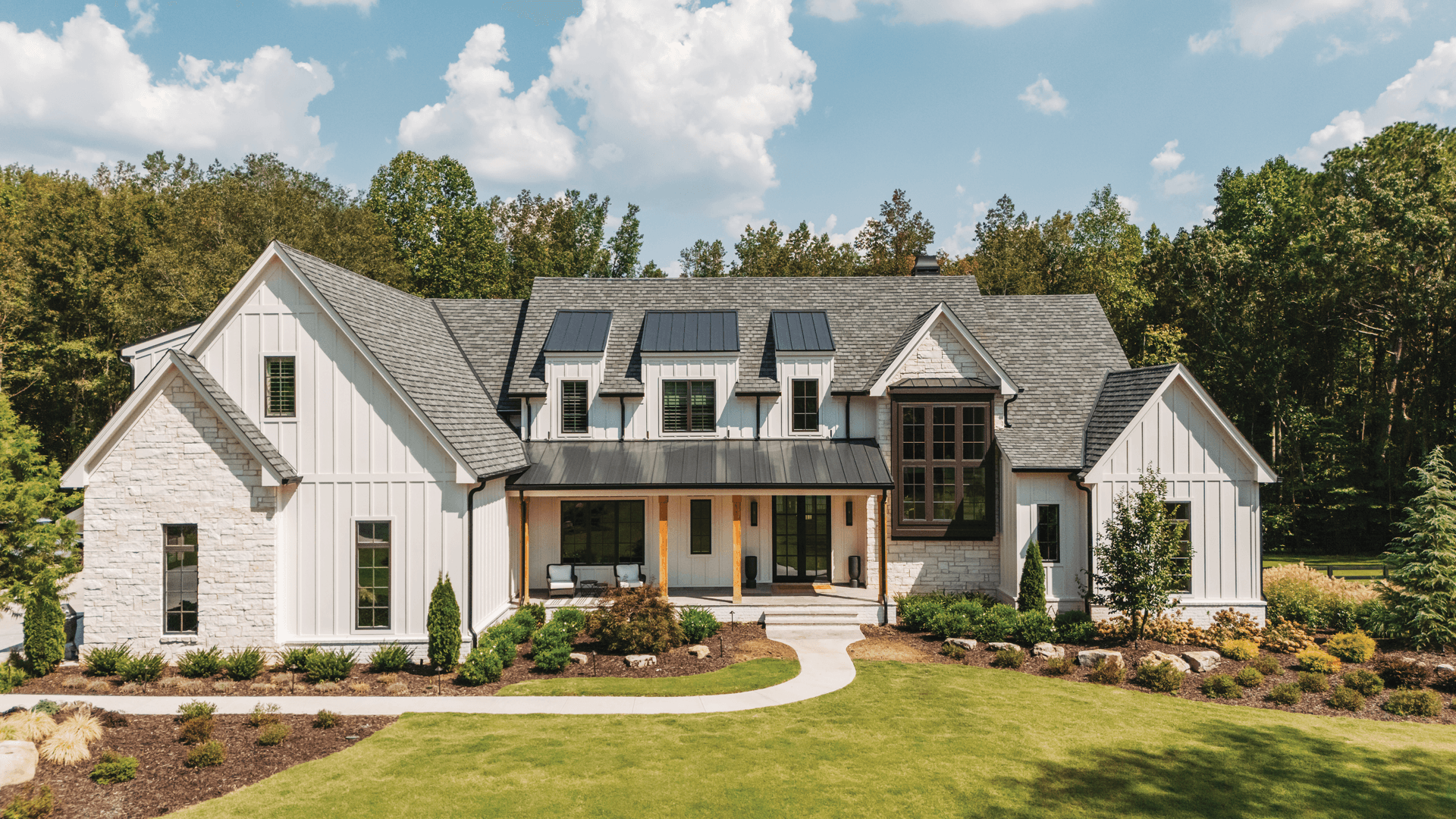 The exterior of a modern farmhouse with Infinity windows.