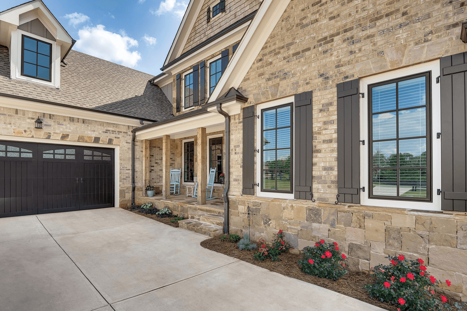 The exterior of a home with stone and brick, featuring Infinity windows.