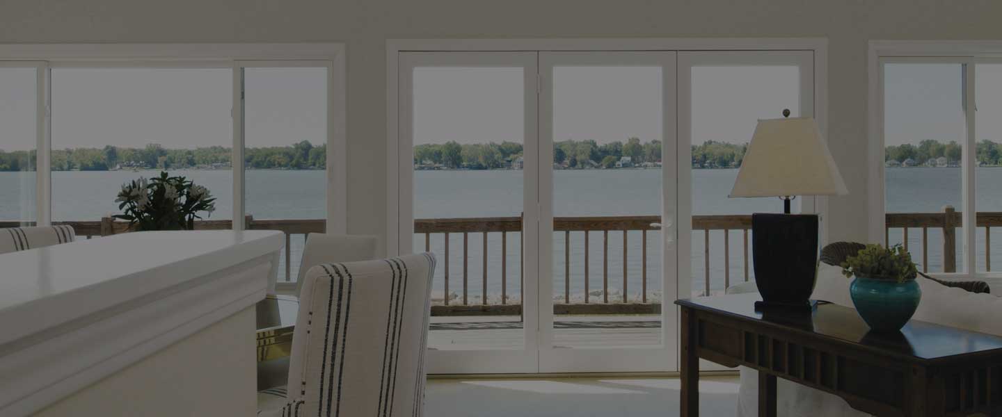 Infinity replacement windows and patio doors in a living room overlooking a lake.